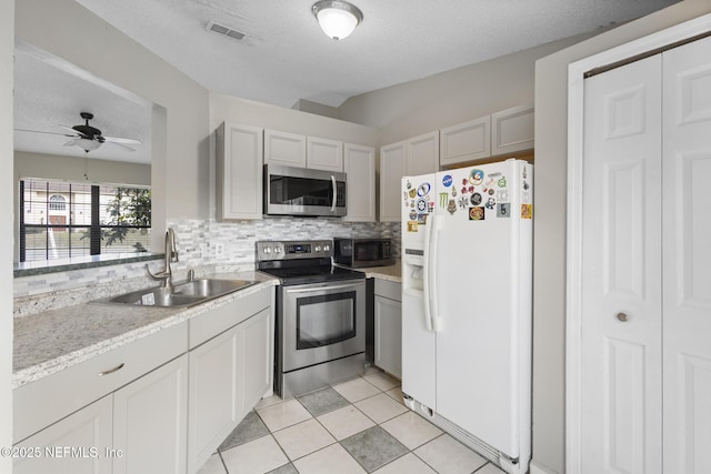 kitchen featuring ceiling fan, sink, a textured ceiling, and stainless steel appliances