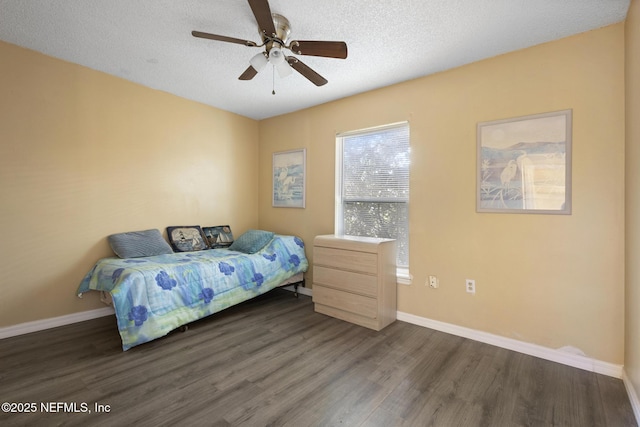 bedroom with ceiling fan, dark hardwood / wood-style floors, and a textured ceiling