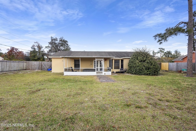 back of property featuring a lawn and a sunroom