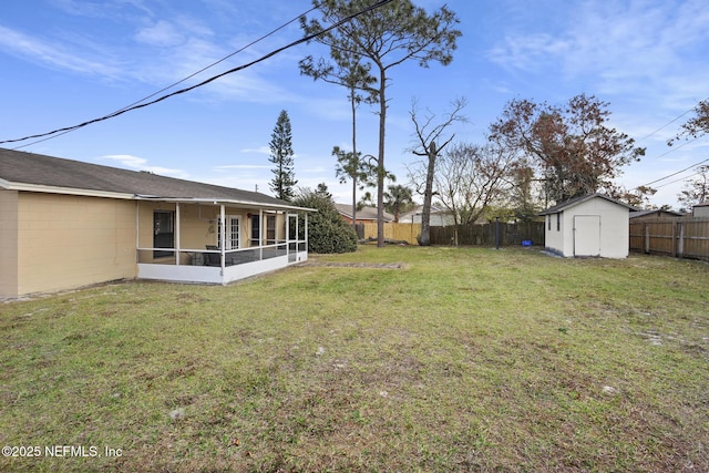 view of yard featuring a sunroom and a storage unit