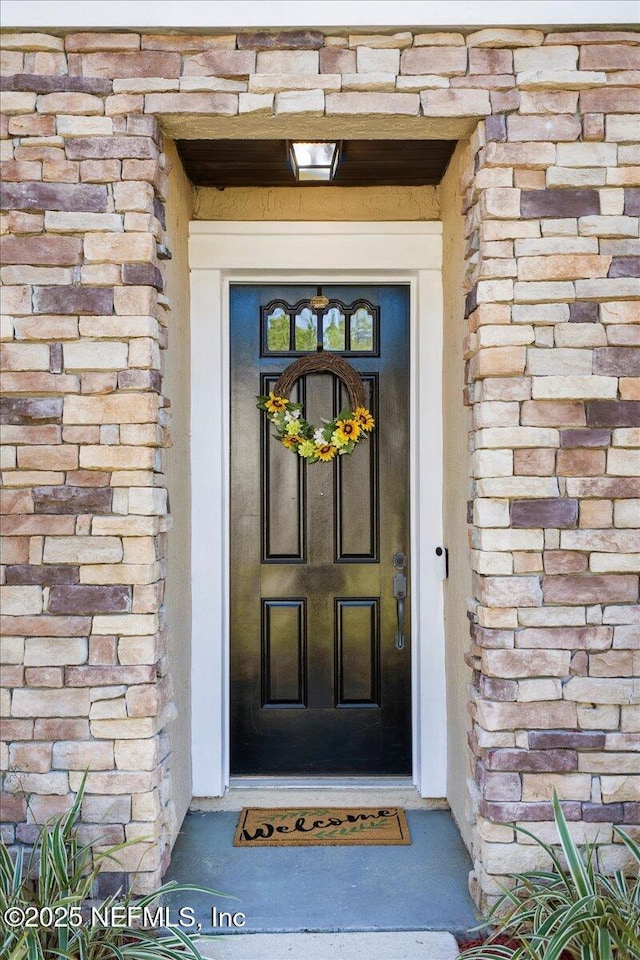 property entrance with stone siding