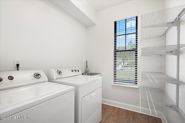 clothes washing area featuring a sink, baseboards, laundry area, washer and dryer, and dark wood-style flooring