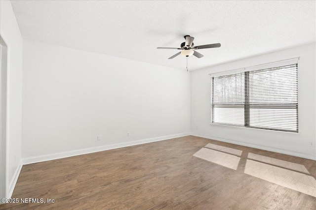 unfurnished room with ceiling fan, wood finished floors, baseboards, and a textured ceiling