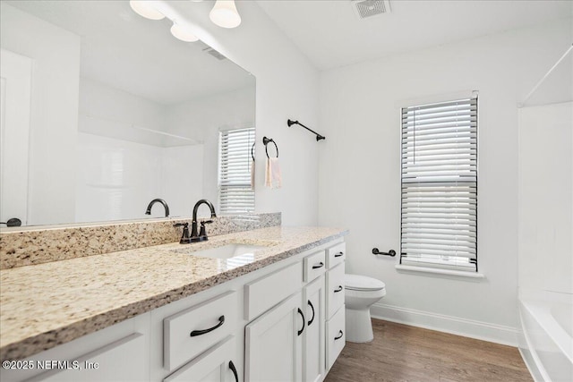 full bath featuring visible vents, toilet, wood finished floors, vanity, and a shower