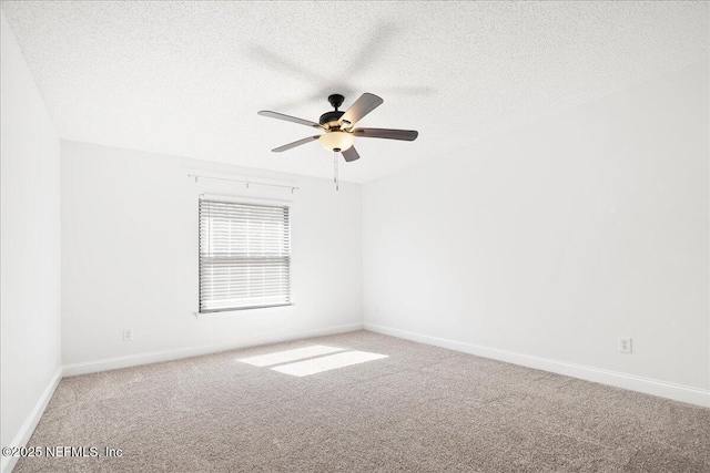 carpeted empty room featuring a ceiling fan, baseboards, and a textured ceiling