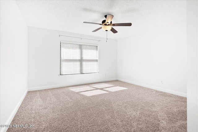 carpeted empty room featuring baseboards, a textured ceiling, and a ceiling fan