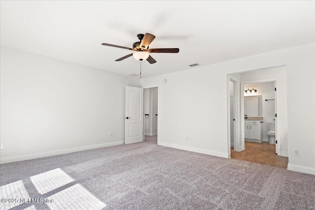 unfurnished bedroom with visible vents, baseboards, ensuite bath, and carpet flooring