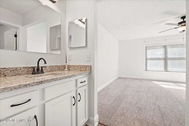 bathroom featuring baseboards, a textured ceiling, ceiling fan, and vanity