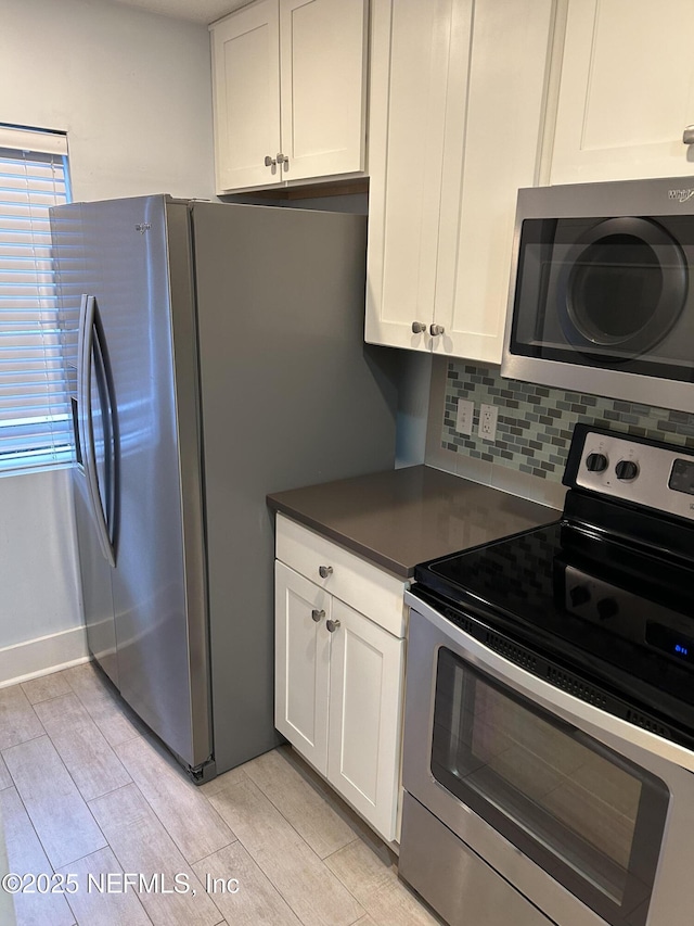 kitchen featuring appliances with stainless steel finishes, white cabinets, and backsplash