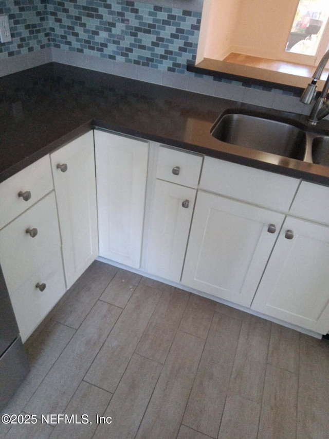 kitchen featuring sink, white cabinets, and decorative backsplash