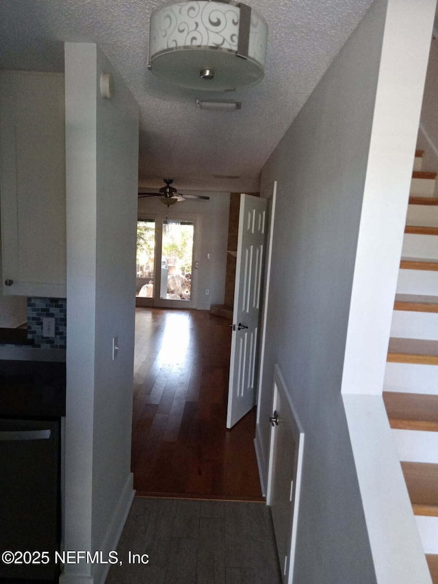 hall with dark hardwood / wood-style floors and a textured ceiling