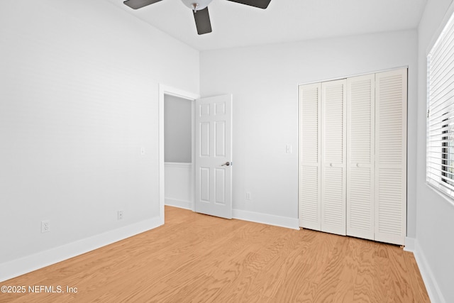 unfurnished bedroom featuring a ceiling fan, a closet, baseboards, and wood finished floors