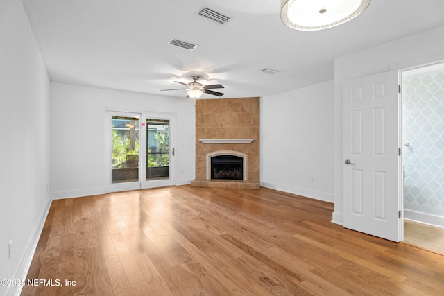 unfurnished living room featuring light wood-style floors, visible vents, a fireplace, and baseboards