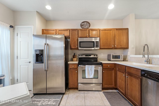 kitchen with light tile patterned floors, sink, and appliances with stainless steel finishes