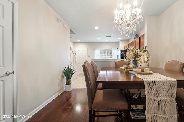 dining space with a chandelier and dark hardwood / wood-style flooring