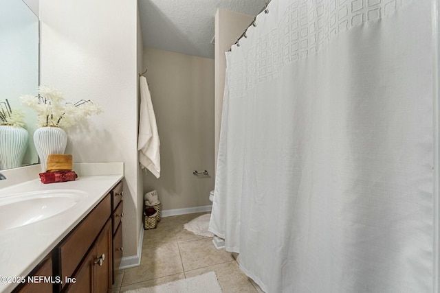 bathroom featuring vanity, a textured ceiling, and tile patterned flooring