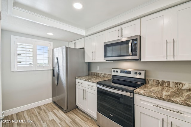 kitchen with crown molding, stainless steel appliances, and white cabinetry