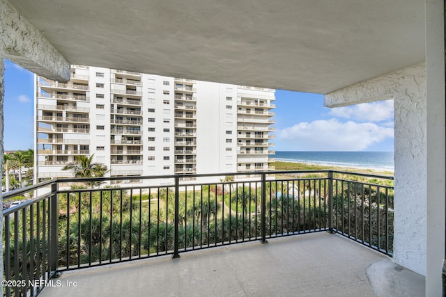 balcony with a water view and a beach view