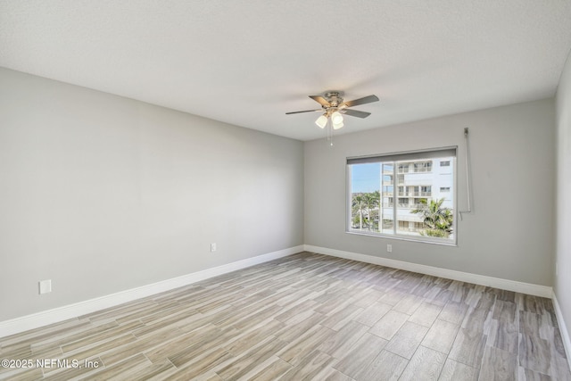 empty room featuring ceiling fan and light hardwood / wood-style flooring