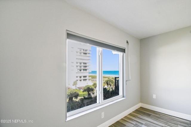 unfurnished room featuring light wood-type flooring and a water view