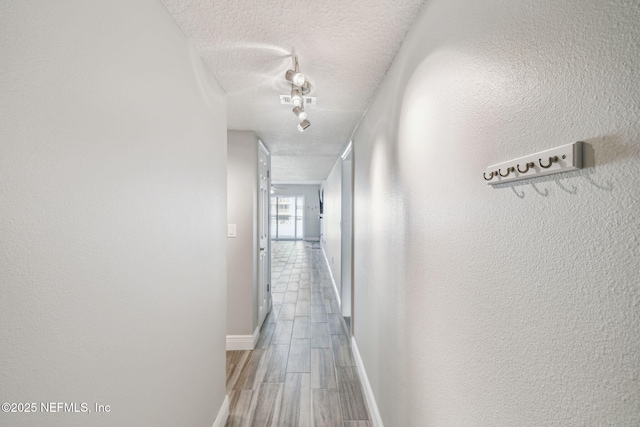 hall with a textured ceiling and hardwood / wood-style floors