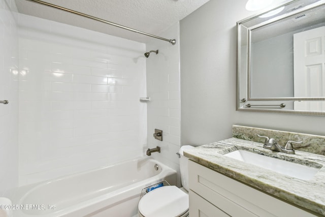 full bathroom with tiled shower / bath, vanity, a textured ceiling, and toilet