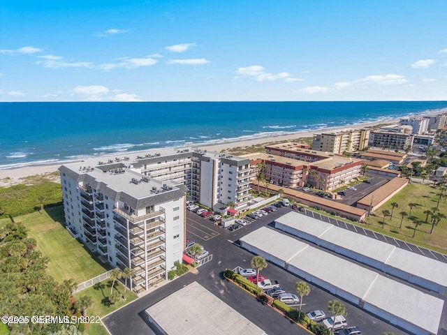 birds eye view of property with a water view and a view of the beach