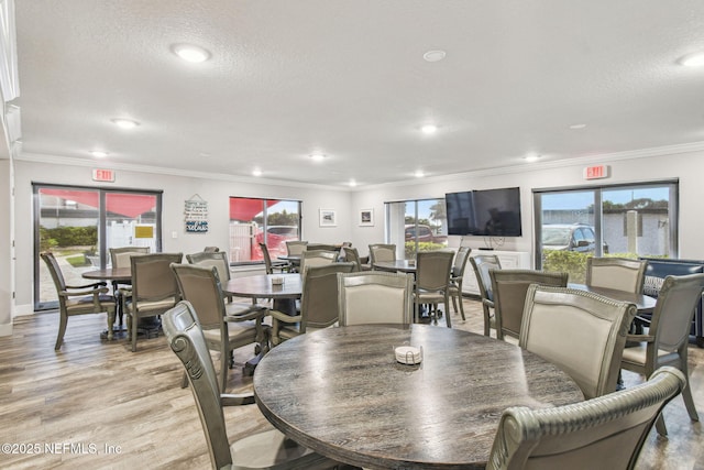 dining area featuring crown molding, a textured ceiling, and light hardwood / wood-style floors