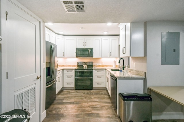 kitchen with dishwashing machine, refrigerator with ice dispenser, range with two ovens, sink, and electric panel