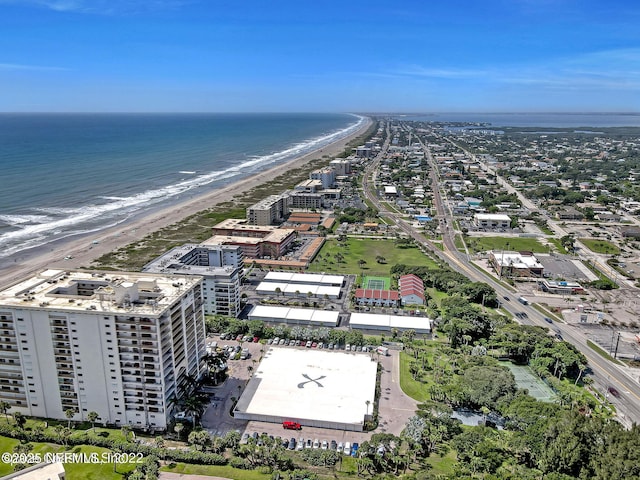 birds eye view of property with a water view and a beach view