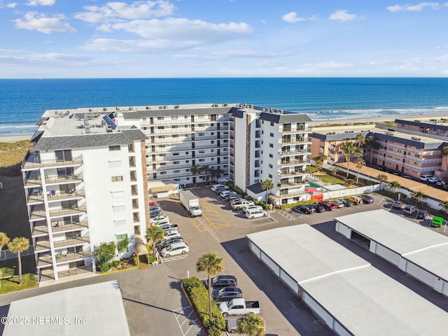 birds eye view of property with a water view and a beach view