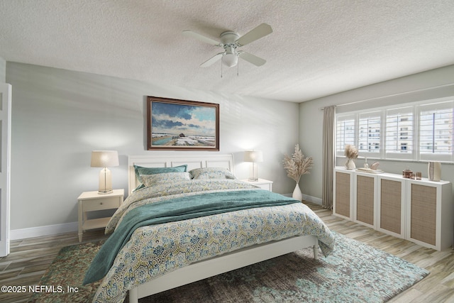 bedroom featuring wood-type flooring, ceiling fan, and a textured ceiling