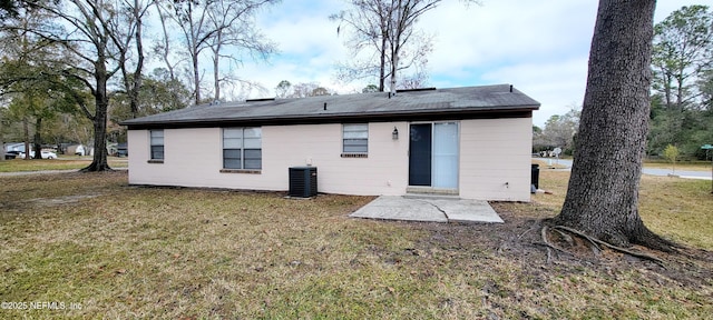 rear view of property with a yard and central air condition unit