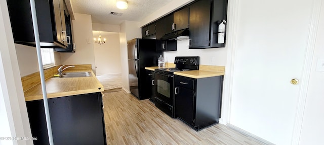 kitchen with sink, decorative light fixtures, a textured ceiling, light hardwood / wood-style floors, and black appliances