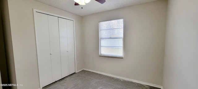 unfurnished bedroom with ceiling fan, multiple windows, a closet, and a textured ceiling