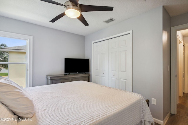 bedroom with ceiling fan, wood-type flooring, and a closet