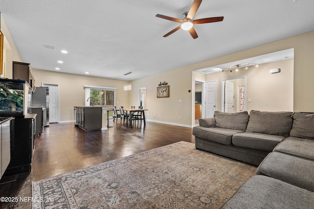 living room with ceiling fan, sink, and dark hardwood / wood-style flooring