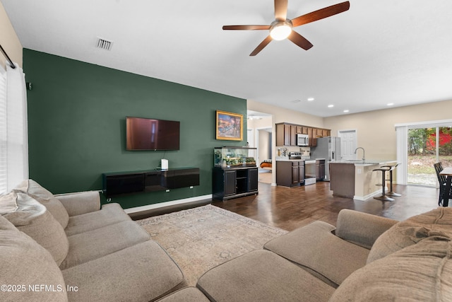 living room with ceiling fan, dark wood-type flooring, and sink