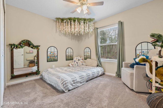 bedroom featuring ceiling fan with notable chandelier and carpet