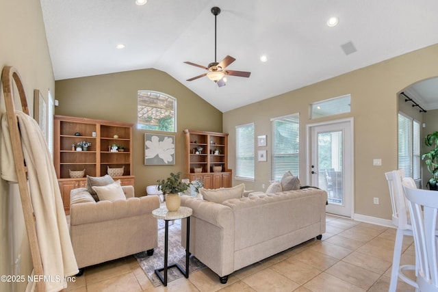 living room with ceiling fan, light tile patterned floors, and vaulted ceiling