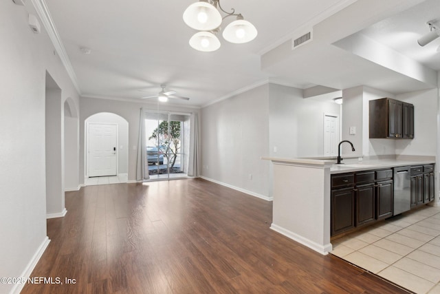 kitchen featuring ceiling fan with notable chandelier, dark brown cabinetry, dishwasher, sink, and crown molding