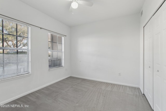 unfurnished bedroom with ceiling fan, light colored carpet, and a closet