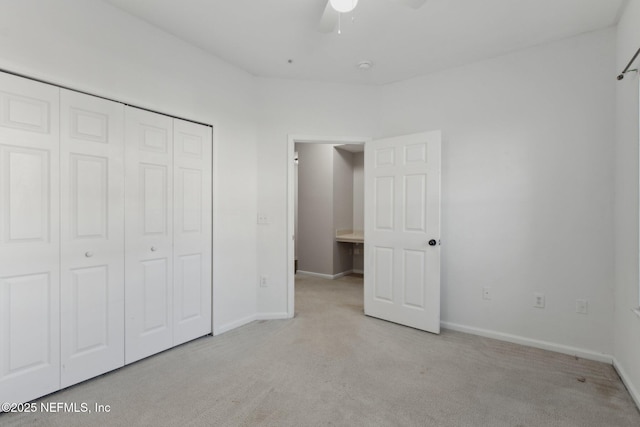 unfurnished bedroom with ceiling fan, a closet, and light colored carpet