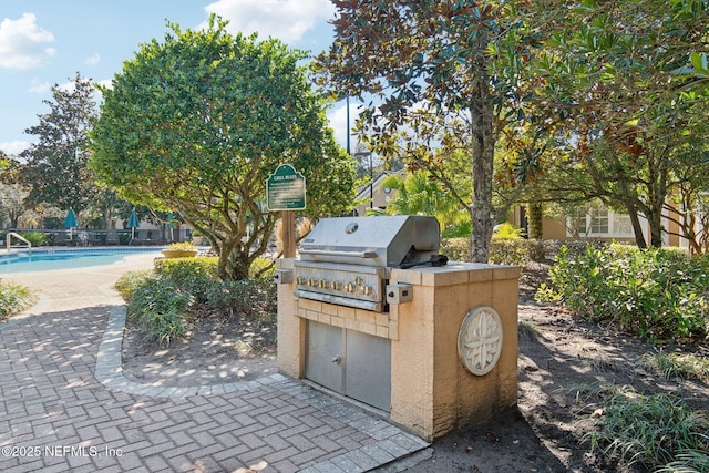 view of patio / terrace featuring exterior kitchen, a fenced in pool, and grilling area