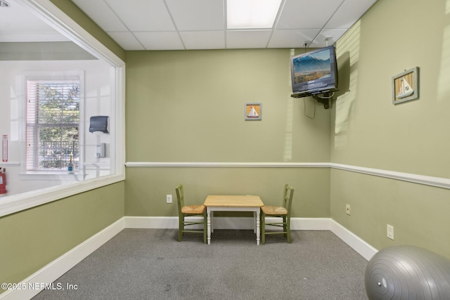 sitting room with carpet floors and a drop ceiling