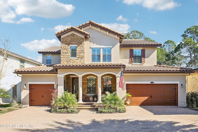 mediterranean / spanish house featuring a porch and a garage