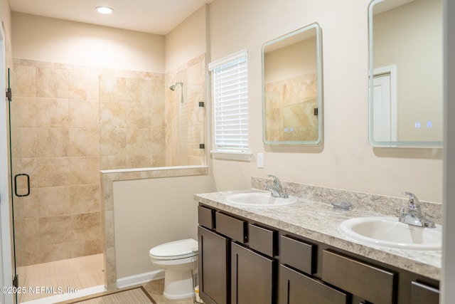 bathroom featuring vanity, toilet, tile patterned flooring, and a shower with door