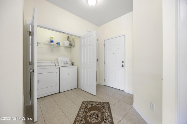 laundry room with light tile patterned flooring and washer and clothes dryer