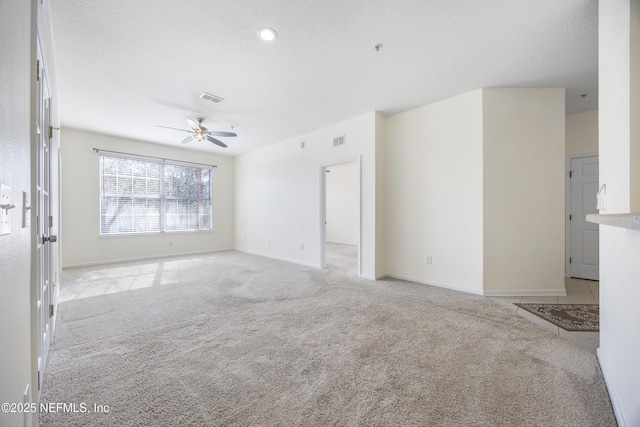 unfurnished room featuring light carpet, ceiling fan, and a textured ceiling