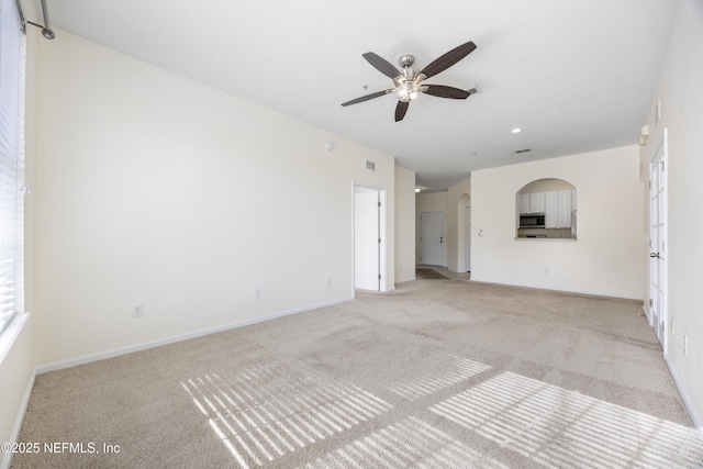 unfurnished living room with light carpet and ceiling fan